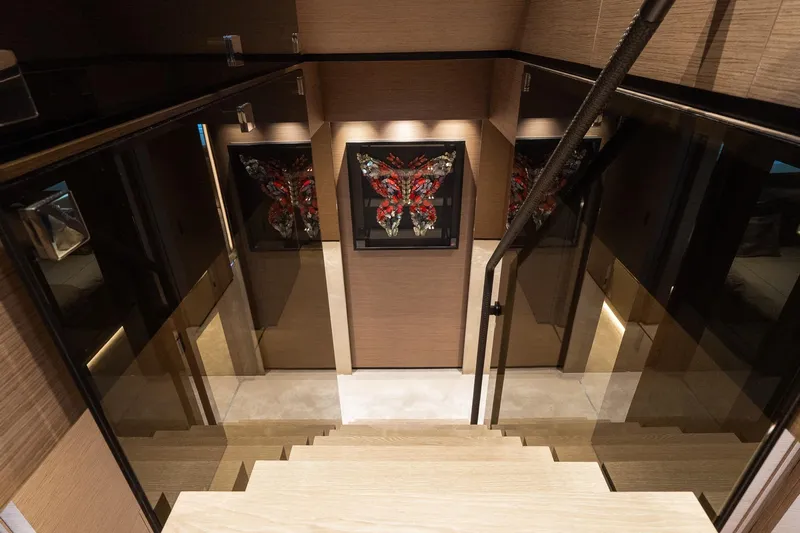 Queen J III Yacht Photos Pics Luxurious interior staircase of 2024 Custom Line Navetta 33 yacht with elegant artwork.