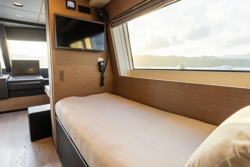 Queen J III Yacht Photos Pics Luxurious 2024 Custom Line Navetta 33 yacht cabin with modern amenities and scenic window view.