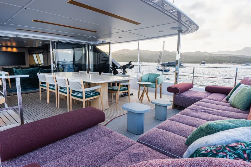 Queen J III Yacht Photos Pics Luxurious 2024 Custom Line Navetta 33 yacht deck with elegant seating and dining area.