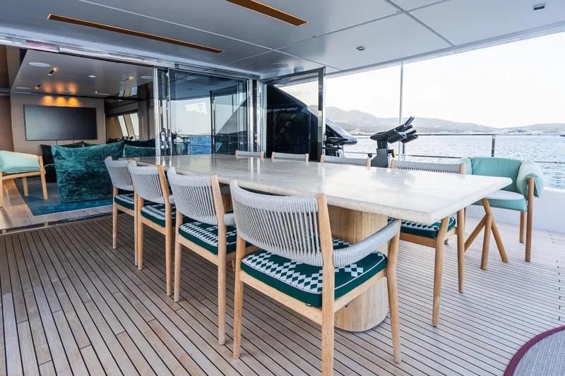 Queen J III Yacht Photos Pics Luxurious 2024 Custom Line Navetta 33 yacht deck with elegant dining area and ocean view.