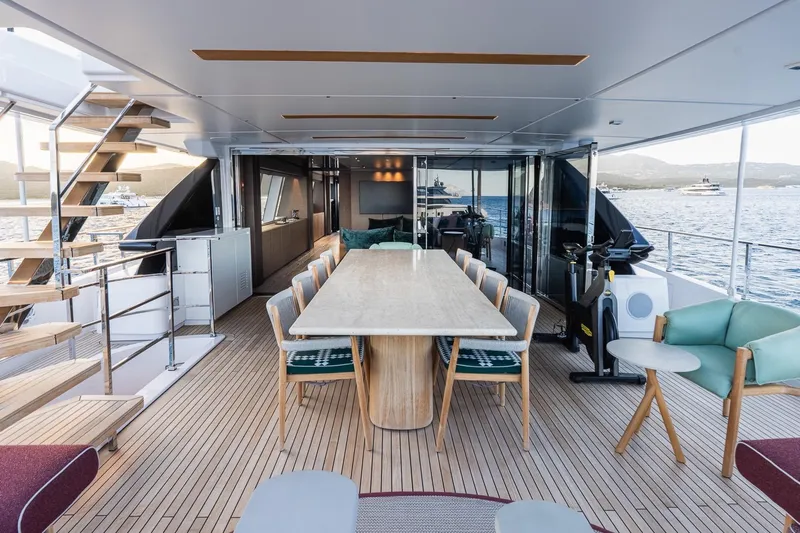 Queen J III Yacht Photos Pics Luxurious 2024 Custom Line Navetta 33 yacht deck with elegant dining area and ocean view.