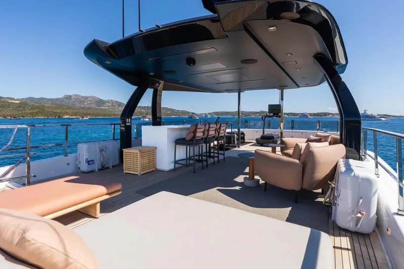 Queen J III Yacht Photos Pics Luxurious 2024 Custom Line Navetta 33 yacht deck with seating, bar, and ocean view.