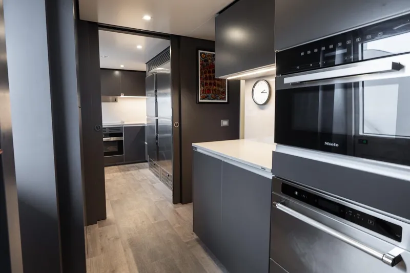 Queen J III Yacht Photos Pics Modern kitchen interior on 2024 Custom Line Navetta 33 yacht, featuring sleek appliances and minimalist design.