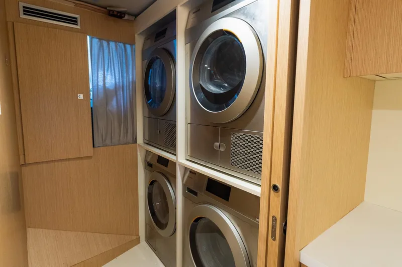 Queen J III Yacht Photos Pics Laundry room with stacked washers and dryers on the 2024 Custom Line Navetta 33 yacht.