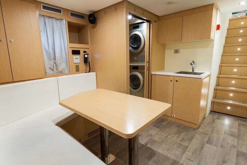 Queen J III Yacht Photos Pics Interior of 2024 Custom Line Navetta 33 yacht with kitchenette, seating, and laundry area.