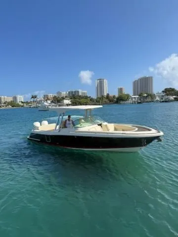  Yacht Photos Pics 2020 Chris-Craft Calypso 30 boat on clear blue water with city skyline in background.