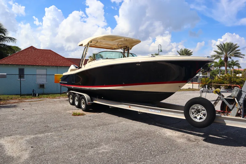  Yacht Photos Pics 2020 Chris-Craft Calypso 30 boat on a trailer, parked outdoors under a blue sky.