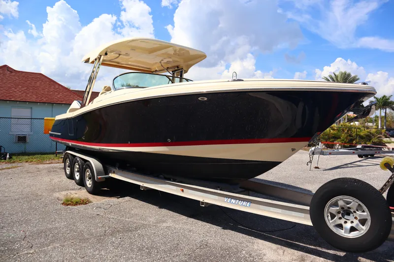  Yacht Photos Pics 2020 Chris-Craft Calypso 30 boat on trailer, parked outdoors under a blue sky.