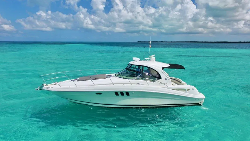 Yacht Photos Pics 2006 Sea Ray Sundancer yacht on clear turquoise water under a partly cloudy sky.