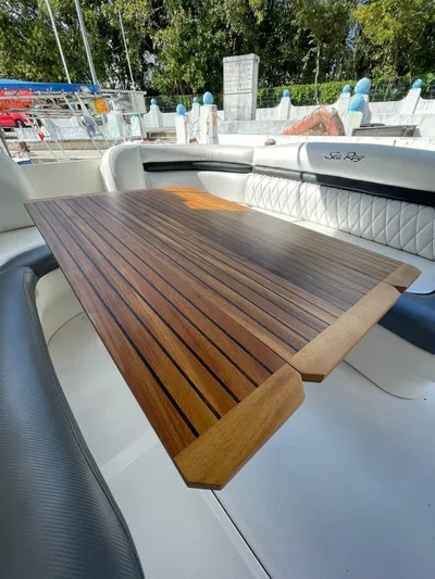  Yacht Photos Pics 2006 Sea Ray Sundancer boat with a wooden table and white seating.