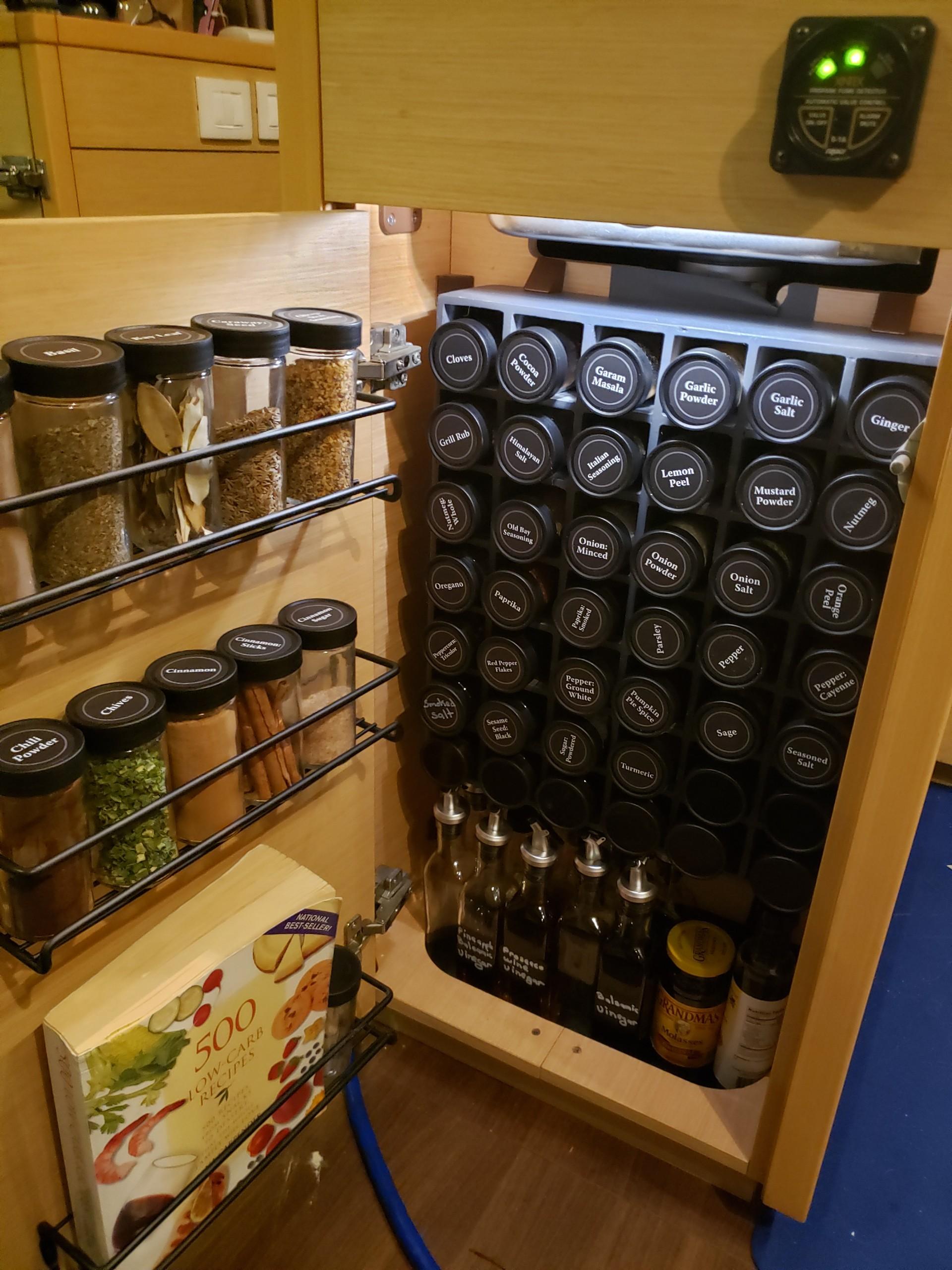 Spice rack in a Lagoon 450 yacht kitchen, neatly organized with labeled jars and bottles.