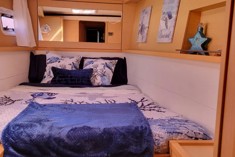 Bear, De Yacht Photos Pics Cozy bedroom in 2011 Lagoon 450 yacht with nautical-themed decor and blue accents.