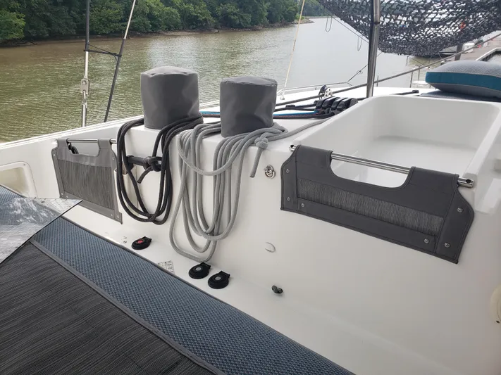 Bear, De Yacht Photos Pics Lagoon 450 catamaran deck with ropes and storage, 2011 model, near a riverbank.