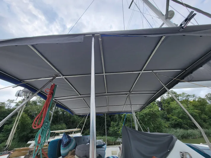 Bear, De Yacht Photos Pics 2011 Lagoon 450 catamaran with a covered deck, ropes, and lush greenery in the background.