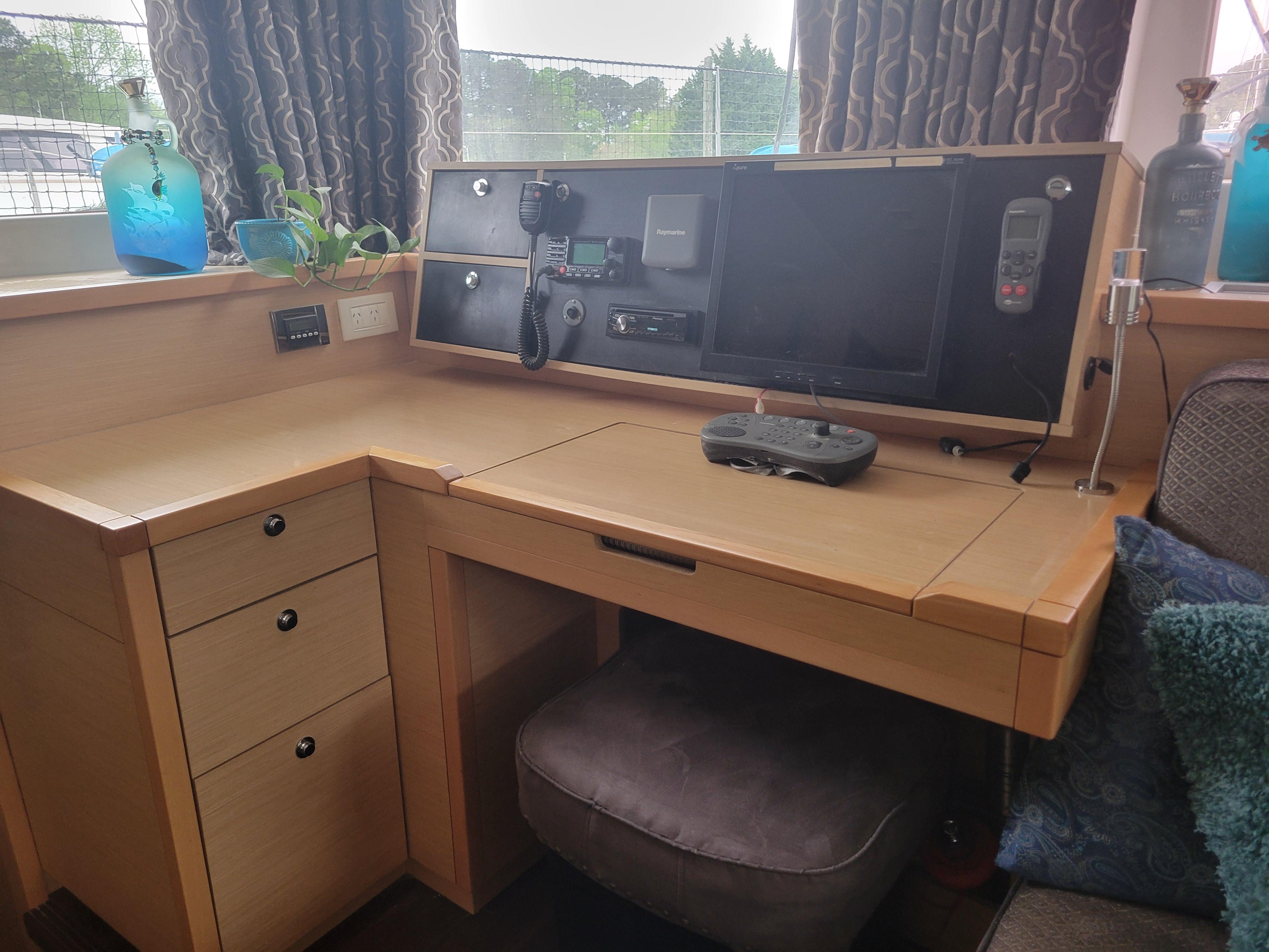 Navigation station inside 2011 Lagoon 450 catamaran with control panel and seating.