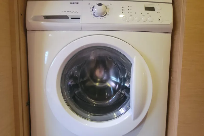 Bear, De Yacht Photos Pics Front-loading washing machine in a wooden cabinet, featuring control knobs and digital display.