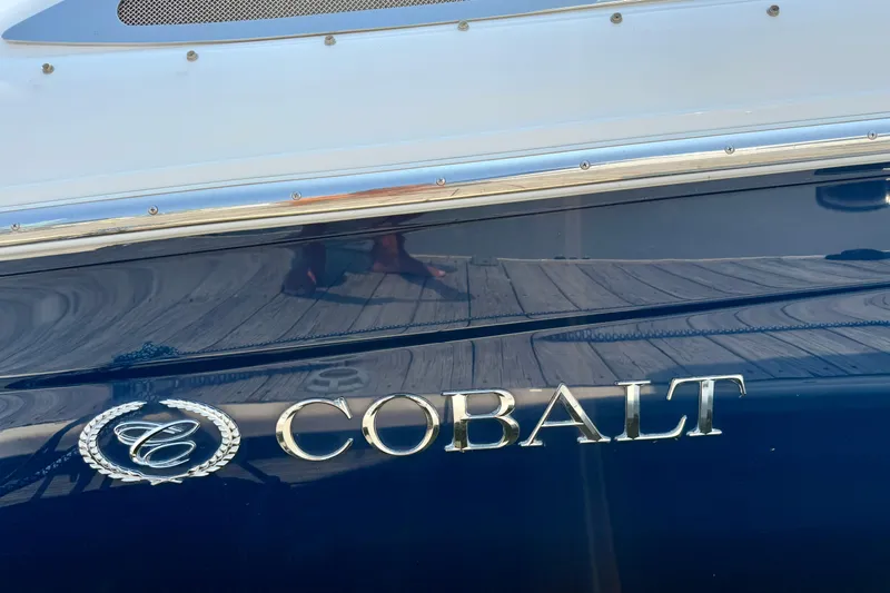  Yacht Photos Pics 2012 Cobalt 323 boat with chrome logo on a sleek blue hull.