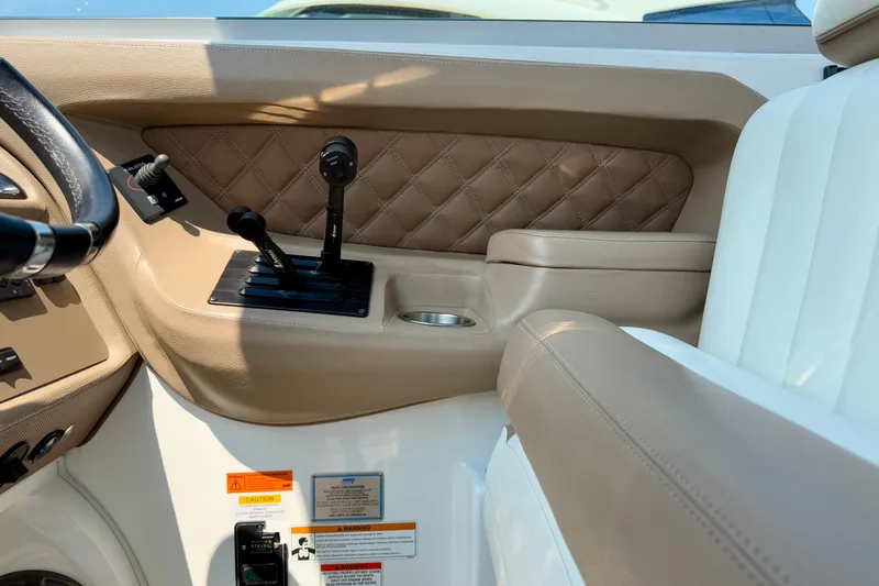  Yacht Photos Pics Interior of a 2012 Cobalt 323 boat, featuring beige leather and control levers.