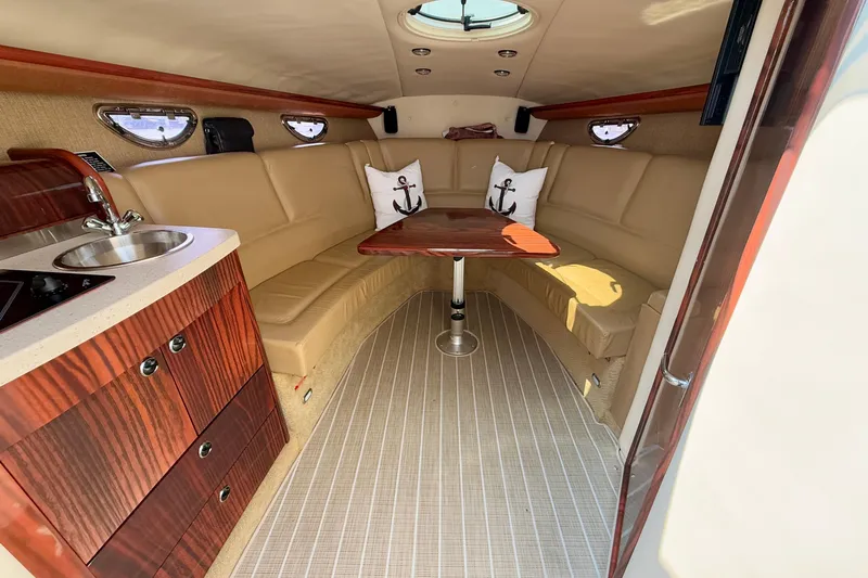  Yacht Photos Pics Luxurious interior of 2012 Cobalt 323 boat with seating, table, and kitchenette.