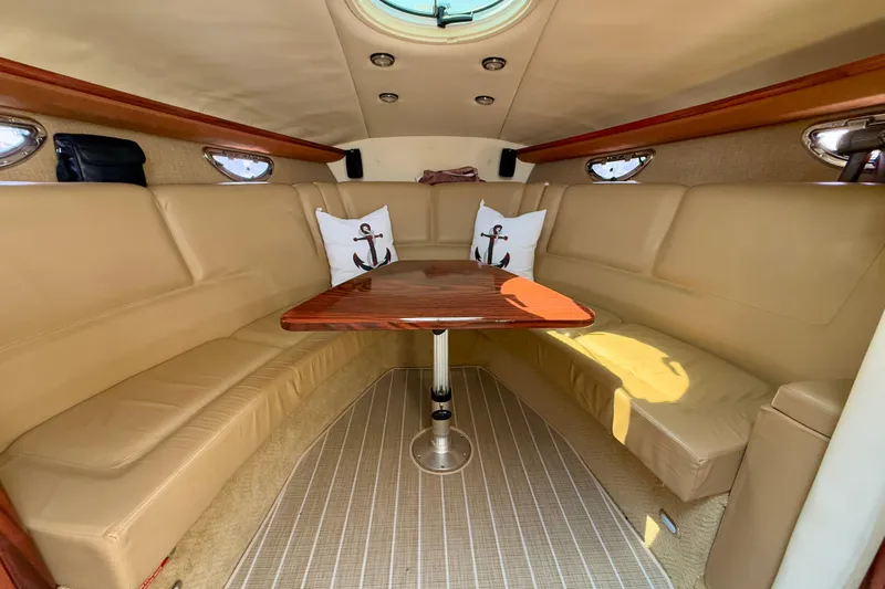  Yacht Photos Pics Luxurious interior of a 2012 Cobalt 323 boat with beige seating and wooden table.