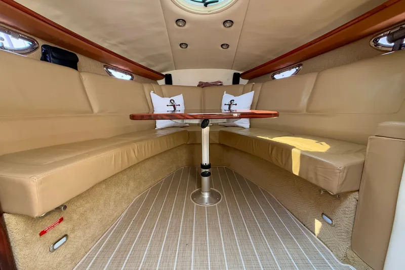  Yacht Photos Pics Interior of a 2012 Cobalt 323 boat with beige seating and wooden table.