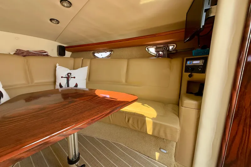  Yacht Photos Pics Interior of 2012 Cobalt 323 boat with beige seating and wooden table.