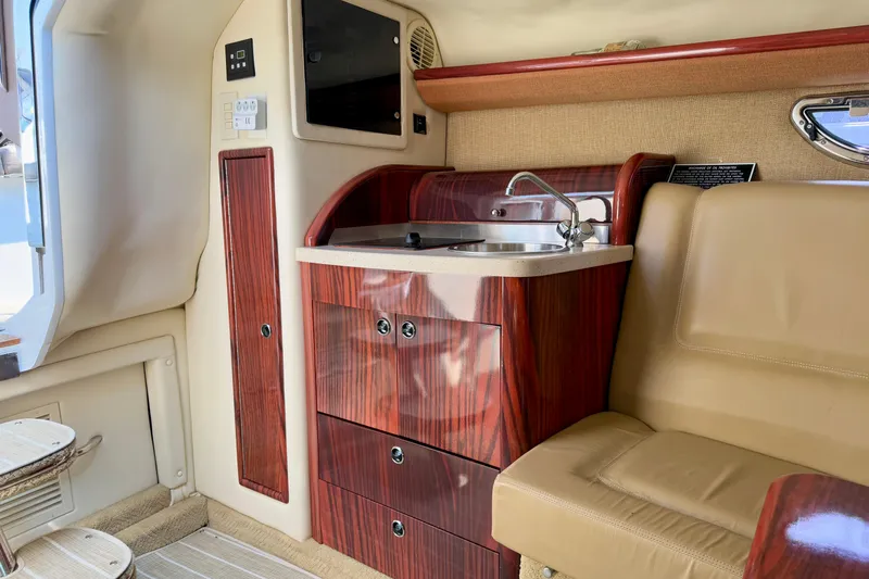  Yacht Photos Pics Luxurious interior of a 2012 Cobalt 323 boat with wood cabinetry and sink.