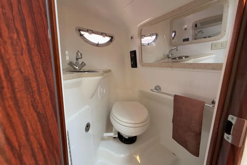  Yacht Photos Pics Compact bathroom in 2012 Cobalt 323 boat with sink, toilet, and mirror.