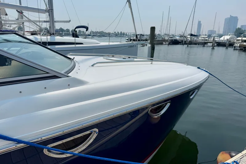 Yacht Photos Pics 2012 Cobalt 323 boat docked in a marina with city skyline in background.
