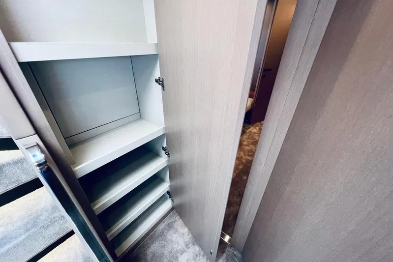  Yacht Photos Pics 2023 Azimut S7 yacht interior with open storage cabinet and carpeted floor.