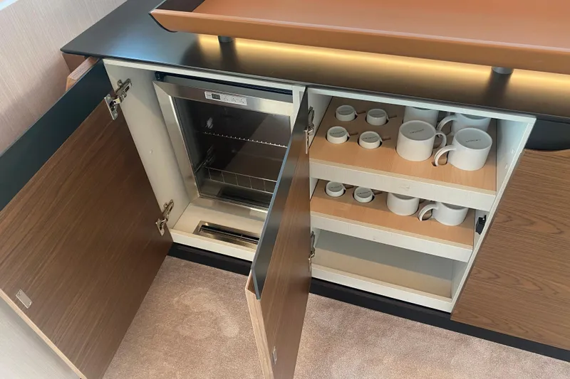  Yacht Photos Pics 2023 Azimut S7 yacht interior with open cabinet, showcasing shelves and a mini fridge.