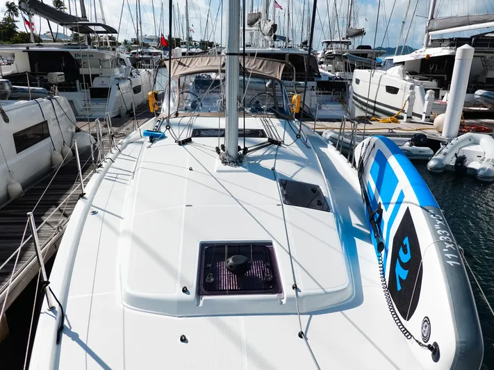 Easy Skanking Yacht Photos Pics 2024 Jeanneau Sun Odyssey 410 sailboat docked, featuring a sleek deck and paddleboard.