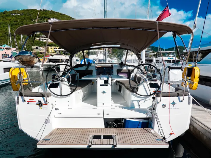 Easy Skanking Yacht Photos Pics 2024 Jeanneau Sun Odyssey 410 yacht docked, featuring dual steering wheels and a spacious cockpit.