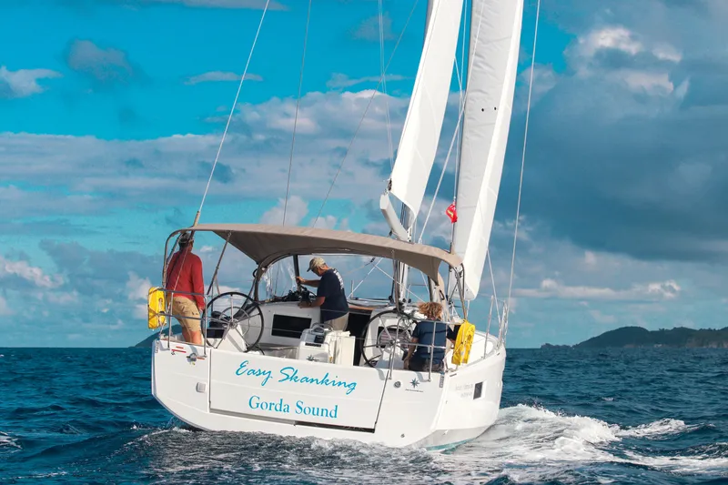 Easy Skanking Yacht Photos Pics 2024 Jeanneau Sun Odyssey 410 sailing on open sea under clear blue skies.