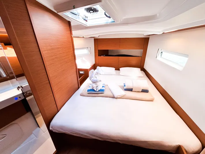Easy Skanking Yacht Photos Pics Luxurious cabin interior of 2024 Jeanneau Sun Odyssey 410 sailboat, featuring a cozy double bed.