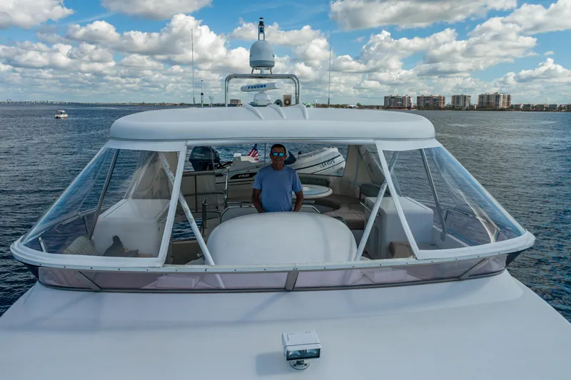  Yacht Photos Pics 2003 Horizon 62 Sport Yacht on water, with person at helm, under blue sky.