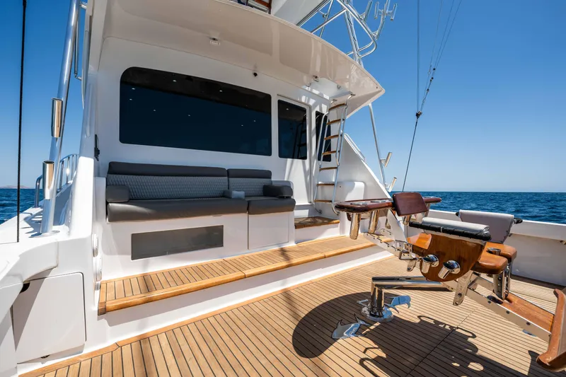 Santana Yacht Photos Pics 2003 Viking 65 Convertible yacht deck with seating and fishing equipment, set against a clear blue sea.