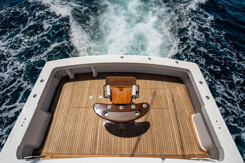 Santana Yacht Photos Pics 2003 Viking 65 Convertible yacht deck with fishing chair, cruising on open water.