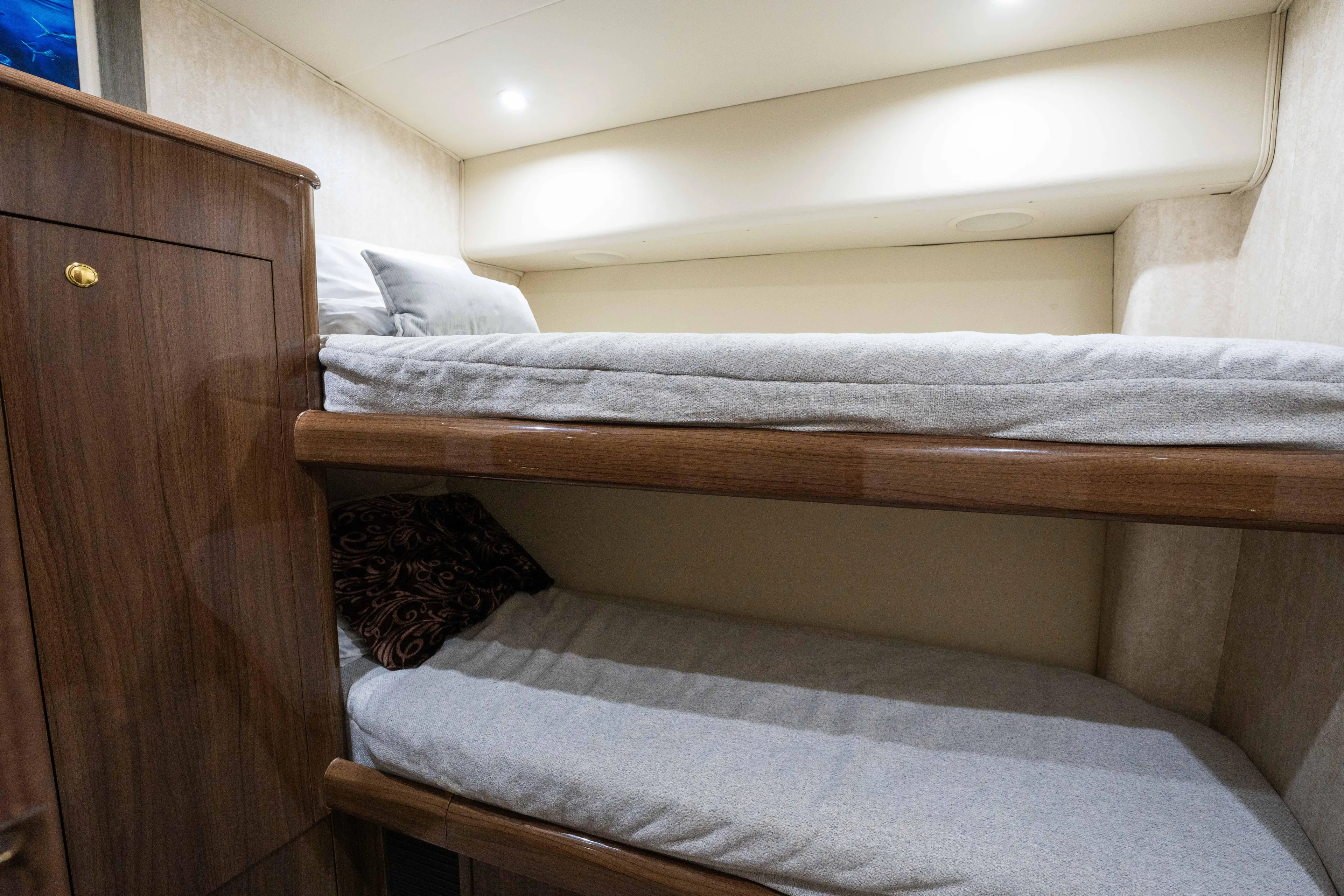 Santana Yacht Photos Pics Bunk beds in 2003 Viking 65 Convertible yacht cabin, featuring wooden finishes and cozy bedding.