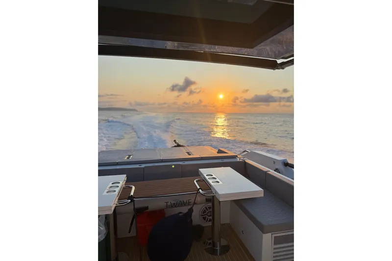  Yacht Photos Pics 2025 De Antonio Yachts D50 cruising at sunset, featuring elegant deck seating and ocean views.