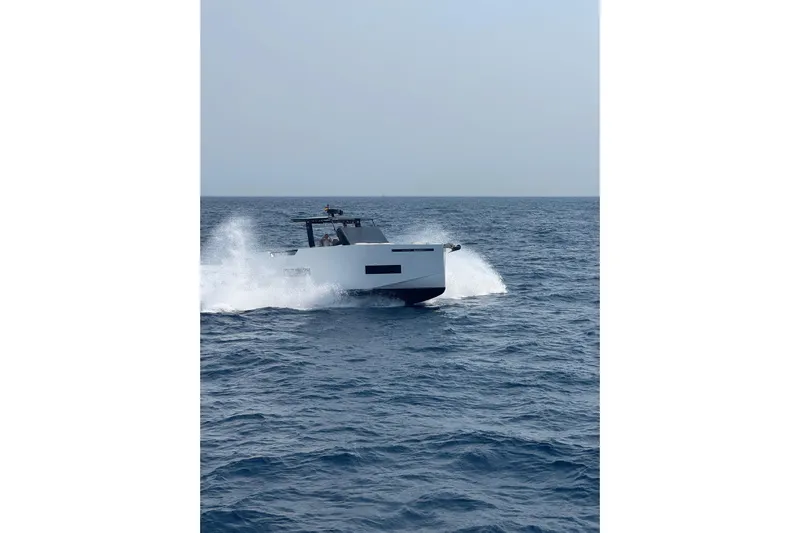  Yacht Photos Pics 2025 De Antonio Yachts D50 cruising on open sea, creating waves.
