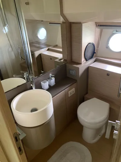 4771 Yacht Photos Pics Luxurious bathroom in 2013 Ferretti 720 yacht with modern fixtures and porthole window.