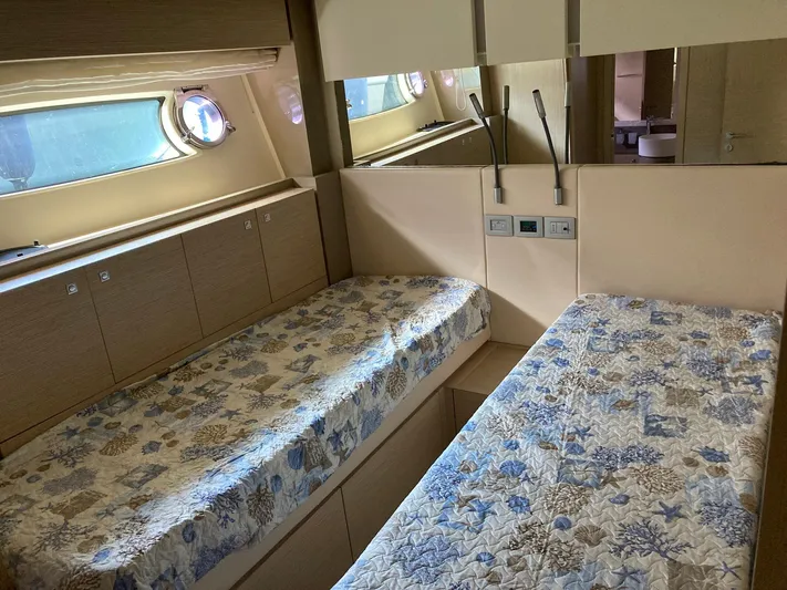 4771 Yacht Photos Pics Twin cabin interior of 2013 Ferretti Yachts 720 with patterned bedding and porthole windows.