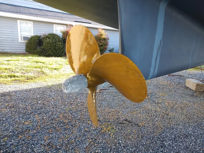 Mother Ship Yacht Photos Pics Catalina 445 sailboat propeller, 2022 model, on gravel with house in background.