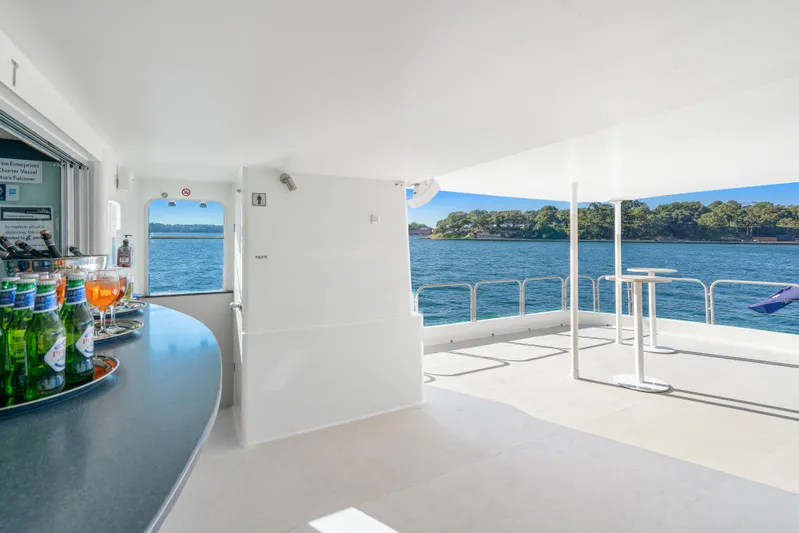 Coast Yacht Photos Pics Spacious deck of 2006 Suncoast 65 yacht with bar, overlooking serene waters and lush shoreline.