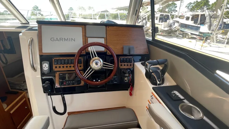  Yacht Photos Pics 2023 Cutwater C-288 boat helm with Garmin navigation system and wooden steering wheel.