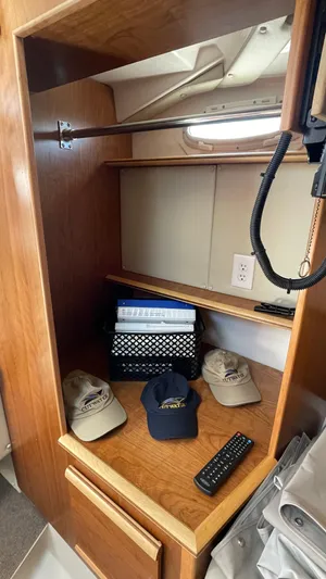  Yacht Photos Pics 2023 Cutwater C-288 interior storage with hats, remote, and organizer on wooden shelves.