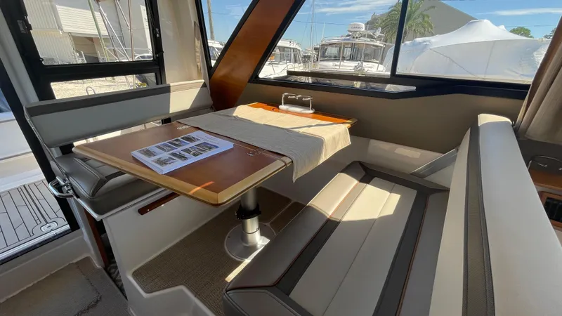  Yacht Photos Pics 2023 Cutwater C-288 interior with dining area, featuring a wooden table and cushioned seating.
