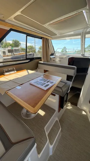  Yacht Photos Pics 2023 Cutwater C-288 interior with seating, table, and windows showcasing a bright, modern design.