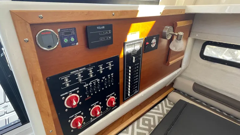  Yacht Photos Pics 2023 Cutwater C-288 control panel with switches and gauges in a wooden frame.